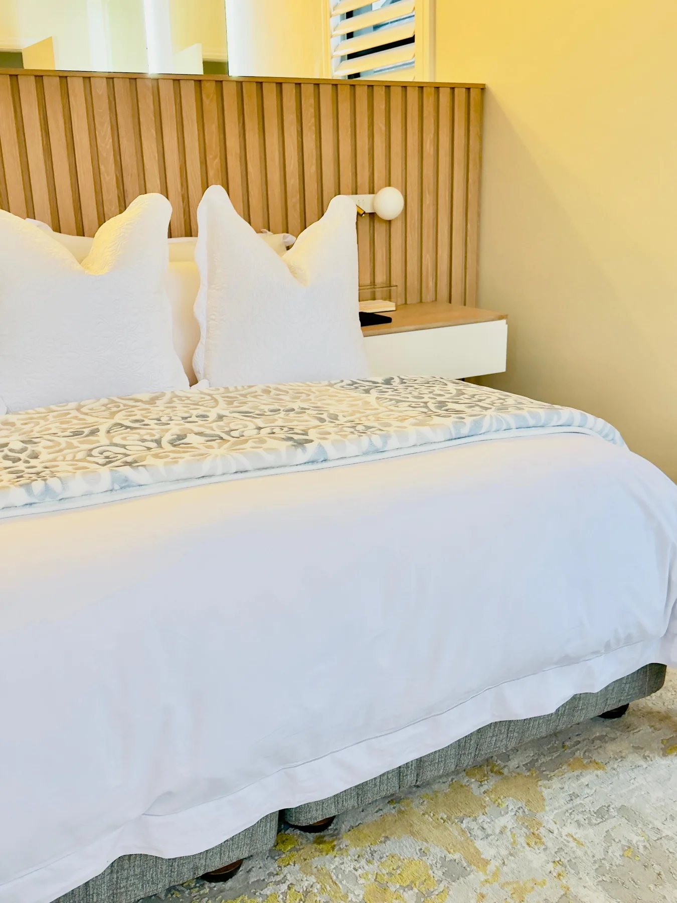 Layered bedroom styling and timber headboard