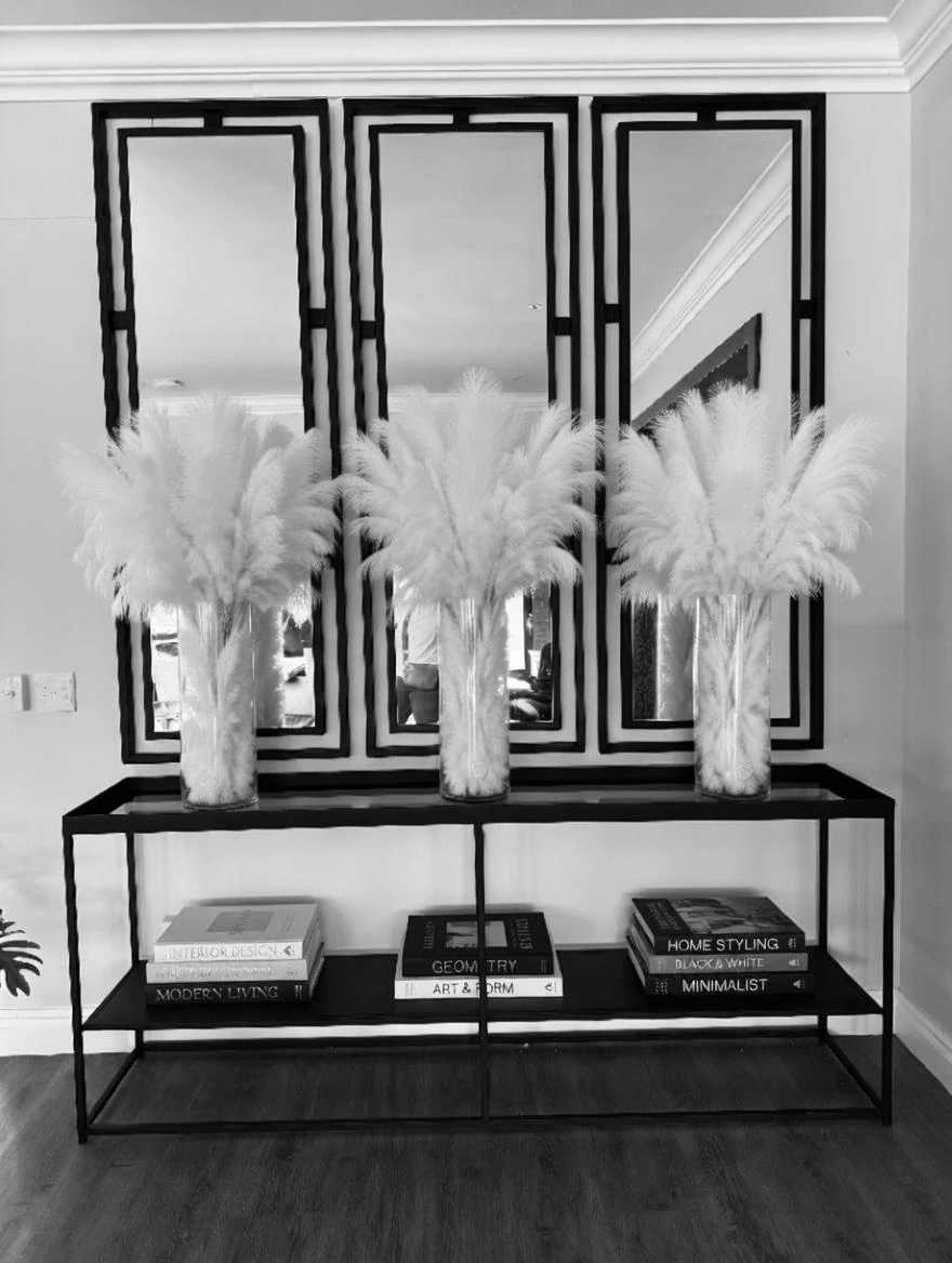 Three framed mirrors above a styled console table